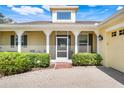 Inviting front porch with screened entry, brick pavers, and meticulously manicured shrubbery at 217 Lake Cassidy Dr, Kissimmee, FL 34759