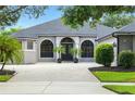 Close up view of a one story home with an arched entry and paver driveway at 2308 Bur Oak Ct, Oviedo, FL 32766