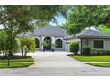 View of a one story home with a well maintained paver driveway and landscaping at 2308 Bur Oak Ct, Oviedo, FL 32766
