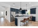 Stylish kitchen featuring navy cabinets, stainless steel appliances, a center island with seating, and white countertops at 2610 Serenity Garden Dr, Kissimmee, FL 34744