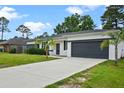 Well-maintained single Gathering home with long driveway, manicured lawn, and attached garage at 2626 Coachman Dr, Deltona, FL 32738