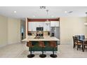Open kitchen with stainless steel appliances, center island with seating, and adjacent dining area at 2626 Coachman Dr, Deltona, FL 32738