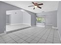 Open-concept living room with tiled floors, neutral walls, and seamless transition to adjacent spaces at 300 Florida Pkwy, Kissimmee, FL 34743