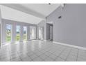 Bright living room featuring high ceilings, tiled floors, and multiple windows for natural light at 300 Florida Pkwy, Kissimmee, FL 34743