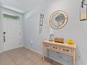 Welcoming entryway with a decorative table, mirror, and stylish tile flooring at 3235 Utah Dr, Deltona, FL 32738