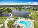 Beautiful aerial view of the community pool, lake, and golf course on a bright, sunny day at 3944 Atrium Dr # 4, Orlando, FL 32822