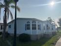 Exterior view of a light blue house featuring a well-manicured lawn, a driveway, and a palm tree at 622 Dreama Dr, Davenport, FL 33897