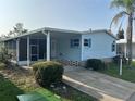 Exterior of a light blue single-story home with a covered carport, a well-maintained lawn, and mature landscaping at 622 Dreama Dr, Davenport, FL 33897