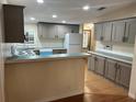 A spacious kitchen with stylish gray cabinets, modern appliances, laminate countertops, and hardwood floors at 622 Dreama Dr, Davenport, FL 33897
