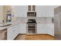 Well-equipped kitchen with sleek white cabinets, stainless steel appliances, and modern countertops at 736 Timacuan Blvd, Lake Mary, FL 32746