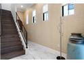 Open staircase with a stylish, modern railing, bright windows, elegant decorations, and marble tile floors at 8113 Via Vittoria Way, Orlando, FL 32819