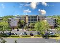 Exterior view of a spacious condo complex with ample parking and mature trees at 9051 Treasure Trove Ln # 505, Kissimmee, FL 34747
