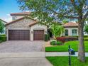 Charming home featuring a three-car garage, lush landscaping, and a tile roof at 9942 Hatton Cir, Orlando, FL 32832