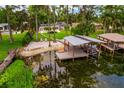 Waterfront property featuring a dock and boat lift, surrounded by lush greenery at 1018 Turner Rd, Winter Park, FL 32789