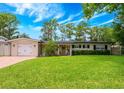 Charming single-story home with a lush green lawn and attached garage at 1018 Turner Rd, Winter Park, FL 32789