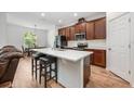 Well-lit kitchen featuring a center island, stainless steel appliances, and dark wood cabinets with modern fixtures at 1027 Eagle Tree Ln, Sanford, FL 32771