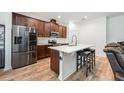 Modern kitchen with stainless steel appliances, stylish countertops, a center island, and dark wood cabinets at 1027 Eagle Tree Ln, Sanford, FL 32771