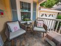 Close up of the front porch with cozy chairs, throw pillows and stone floor at 1041 N Fern Creek Ave, Orlando, FL 32803