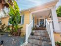 Inviting front porch with stone steps, white railings and cozy seating area at 1041 N Fern Creek Ave, Orlando, FL 32803