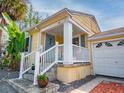 Charming front porch with white railings, stone steps and adjacent garage at 1041 N Fern Creek Ave, Orlando, FL 32803