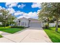 Well-maintained gray home with a spacious driveway, two-car garage, and manicured lawn at 1415 Ellis Fallon Loop, Oviedo, FL 32765