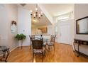 Bright dining area featuring wood floors, chandelier lighting, and seamless access to the kitchen and front entrance at 14224 Colonial Lakes Dr, Orlando, FL 32826