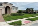 Well-maintained front yard with lush green grass, landscaping, and neighborhood playground at 147 Seville Dr, Davenport, FL 33837