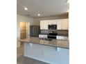 Modern kitchen featuring granite countertops, stainless steel appliances, and ample cabinet space at 1727 Buckeye Rd, Davenport, FL 33837