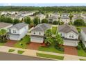 Wide aerial of well maintained single Gathering homes in neighborhood with manicured lawns at 17416 Painted Leaf Way, Clermont, FL 34714