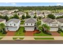 Aerial view of a neighborhood featuring well-maintained homes with green lawns and palm trees at 17416 Painted Leaf Way, Clermont, FL 34714