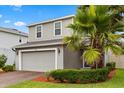 Two-story home with a brick driveway, a two-car garage, and trimmed hedges at 17416 Painted Leaf Way, Clermont, FL 34714