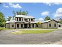 A gorgeous two-story home with a metal roof, dark trim, and circular driveway at 2459 Mcgregor Oaks Ln, Deland, FL 32720