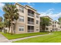 The condo exterior features lush lawn, a walkway and multiple stories with screened in outdoor living spaces at 3000 Laurel Park Ln # 308, Kissimmee, FL 34741
