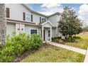 Two-story townhouse featuring lush landscaping, healthy green lawn, and mature shade trees at 3203 Oyster Ln, Kissimmee, FL 34747