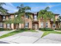 Attractive townhome with tropical landscaping and a brick driveway at 3214 Calabria Avenue, Davenport, FL 33897