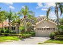 Charming single-story home featuring a two car garage, tiled roof, lush landscaping, and a paved driveway at 3307 Kentshire Blvd, Ocoee, FL 34761