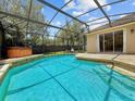 Enjoy a relaxing swim in this screened-in pool with adjacent spa and views of the lush backyard at 3307 Kentshire Blvd, Ocoee, FL 34761