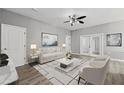 Bright living room featuring neutral paint, modern furniture, ceiling fan and sliding glass doors at 3824 Blue Dasher Dr, Kissimmee, FL 34744