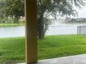 Picturesque view of a serene lake with a fountain from a covered patio overlooking a lush green lawn at 3904 Coastal Breeze Dr, Kissimmee, FL 34744
