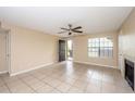 Bright living room with ceiling fan, tile floor, fireplace, and access to balcony at 420 Forestway Cir # 206, Altamonte Springs, FL 32701