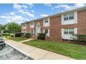 Charming brick townhouse with white shutters, a manicured lawn, and lovely landscaping at 4300 Lake Underhill Rd # D, Orlando, FL 32803