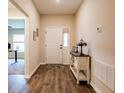 Inviting foyer with stylish wood-look flooring, a charming accent table, and a view into the home at 5416 Tessin Trl, St Cloud, FL 34771