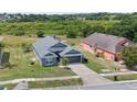 Aerial view of a well-maintained gray single-story home with a two-car garage surrounded by lush greenery at 7744 Country Run Pkwy, Orlando, FL 32818