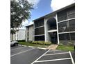 Building exterior featuring screened patios, landscaped bushes, and ample parking spaces at 8211 Sun Spring Cir # 11, Orlando, FL 32825