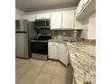 Kitchen with stainless steel appliances, granite countertops, and white cabinets at 8211 Sun Spring Cir # 11, Orlando, FL 32825
