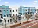 An eye-level view of the modern exteriors of the townhomes, showing the stylish blue and gray color scheme at 879 City Walk Ln, Oviedo, FL 32765