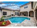 Backyard pool with screen enclosure, spa, fireplace, travertine tile and outdoor seating area at 8814 Southern Breeze Dr, Orlando, FL 32836
