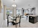 Open dining area with a view of the modern kitchen, living room and access to the outdoor patio at 9061 Dogleg Dr, Davenport, FL 33896