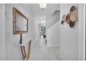 Bright hallway featuring sleek tile flooring, modern decor, and a view into the dining area at 9061 Dogleg Dr, Davenport, FL 33896