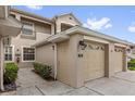 Attached garage featuring an automatic door and well-manicured bushes at 9435 Myrtle Creek Ln # 308, Orlando, FL 32832